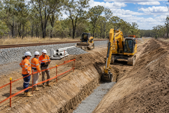 Drainage construction beside rail formation using civil plant and supervised crews