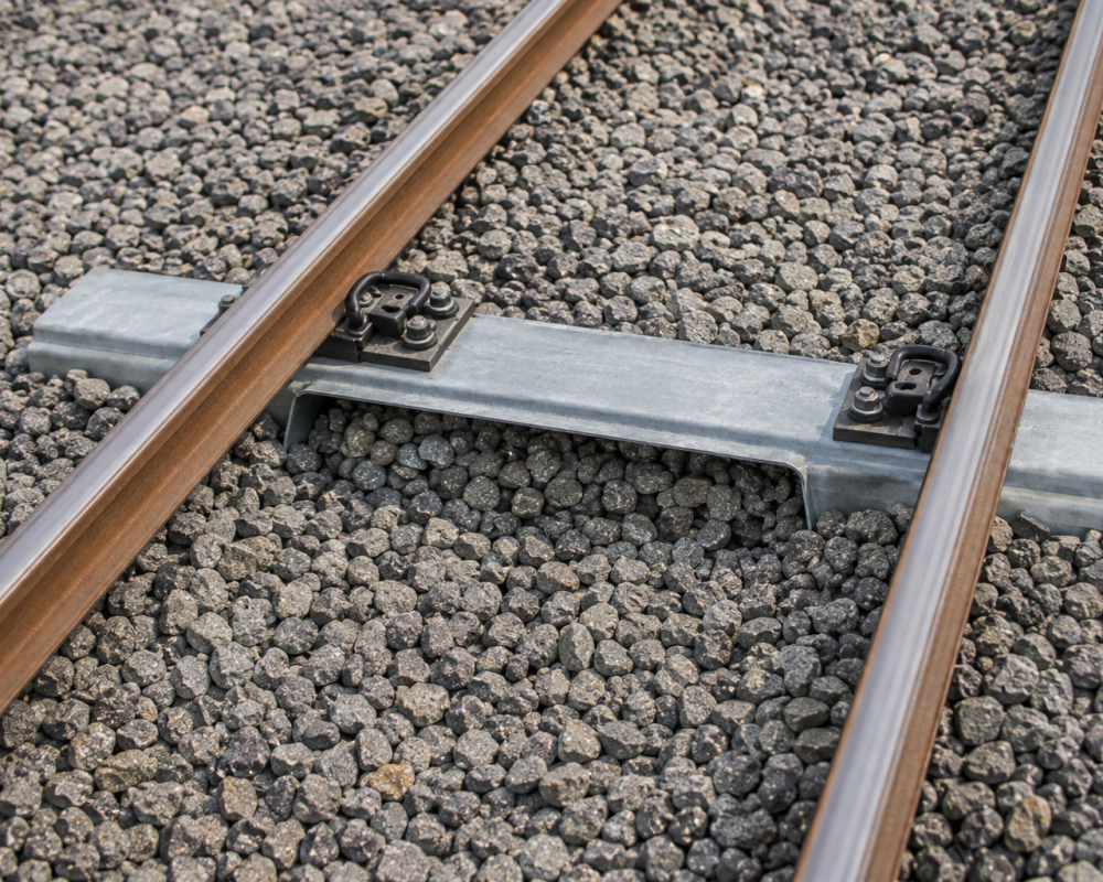 Steel rail sleeper showing compacted ballast support around the sleeper profile